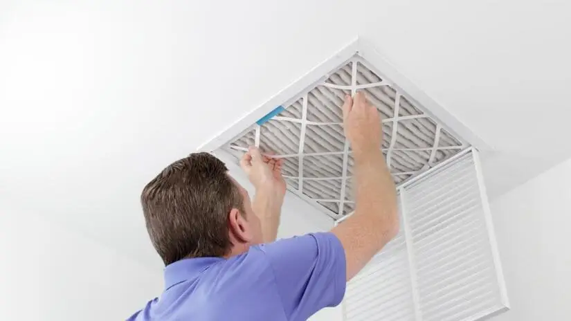 Man cleaning a residential air duct.