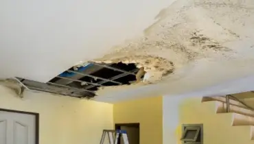 Extensive water damage to ceiling of home with mold visible on ceiling